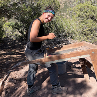 Field school students Jenna Foster screening for artifacts at an excavation in Range Creek Canyon.