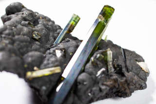 Green elbaite on a manganese oxide mineral. 