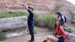 Two teachers and and NHMU instructor look at desert geology